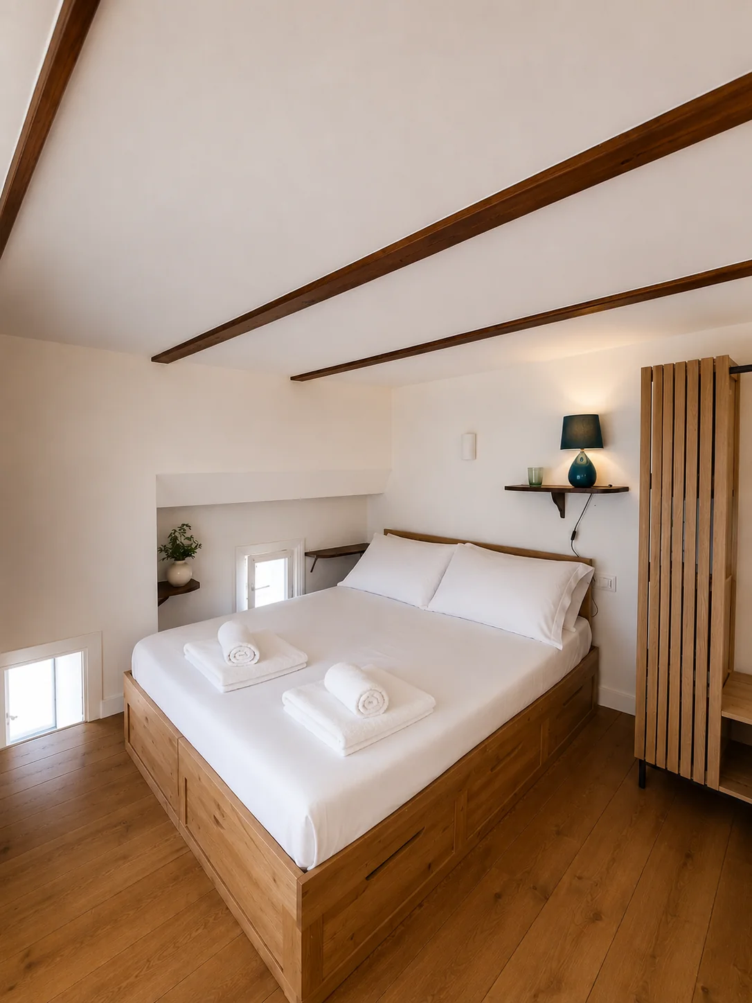Camera da letto con letto matrimoniale e travi in legno